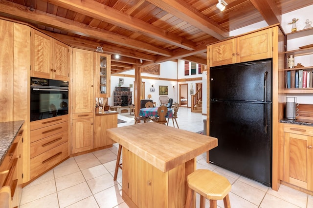 kitchen featuring light tile patterned floors, wood ceiling, a breakfast bar, beamed ceiling, and black appliances