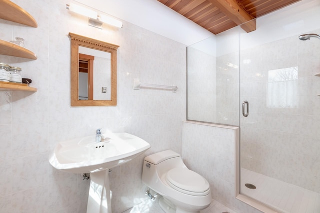 bathroom featuring a stall shower, beamed ceiling, tile walls, and toilet