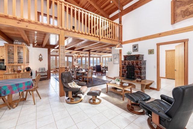 living area with wood ceiling, beamed ceiling, tile patterned flooring, a stone fireplace, and a chandelier