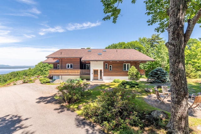 rear view of house with an attached garage, a patio area, and dirt driveway