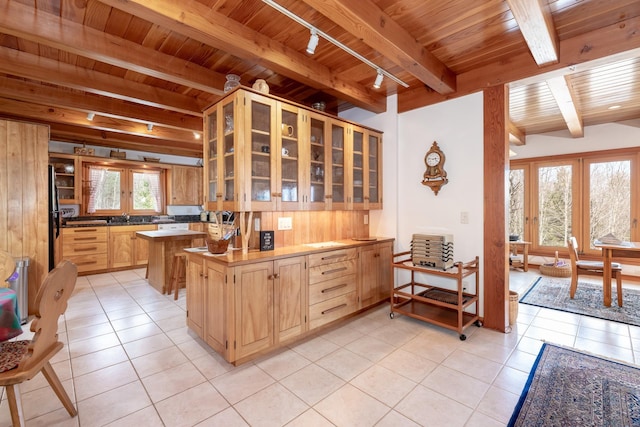 kitchen with french doors, beam ceiling, light tile patterned floors, glass insert cabinets, and wooden ceiling