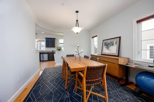 dining area with light wood-style floors and baseboards