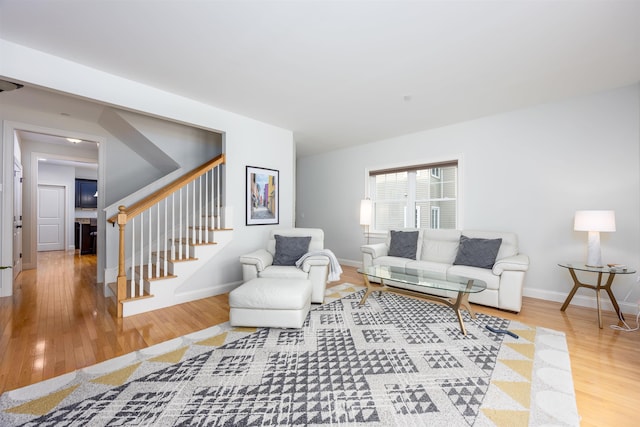 living area featuring stairway, baseboards, and wood finished floors