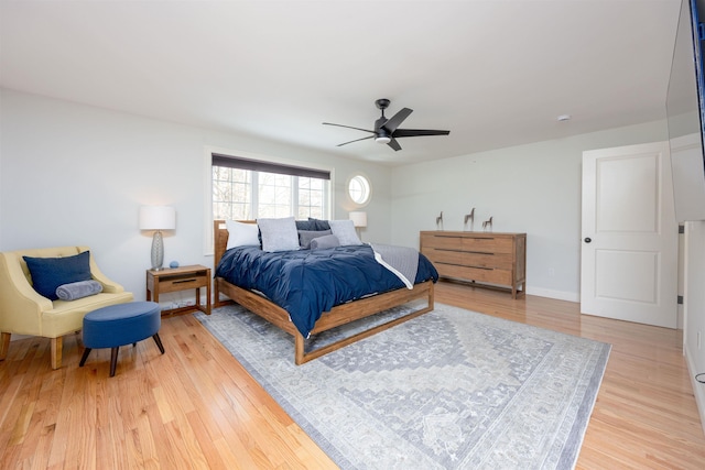 bedroom with light wood-style flooring, baseboards, and a ceiling fan