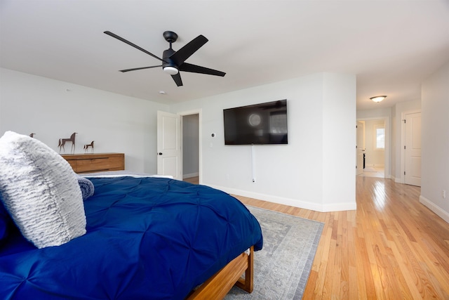 bedroom with light wood-style floors, baseboards, and a ceiling fan