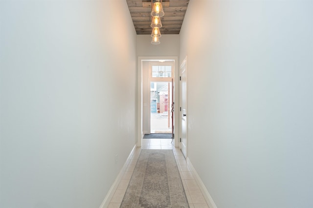 hallway with wooden ceiling, light tile patterned flooring, and baseboards