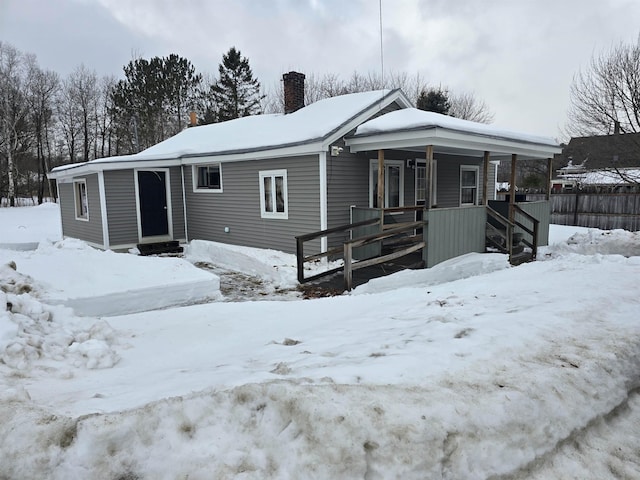 view of front of home with covered porch and a chimney