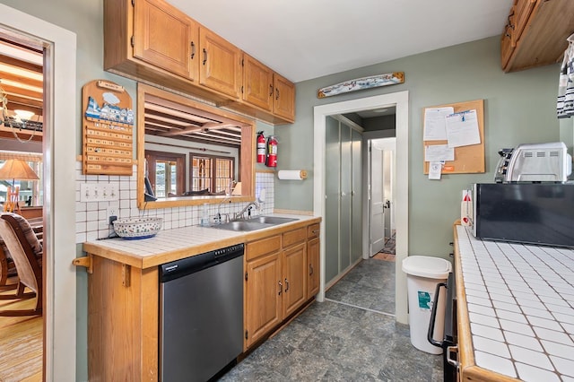 kitchen with a sink, tile counters, decorative backsplash, and dishwasher