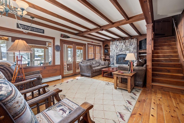 living room with a baseboard radiator, a fireplace, light wood-style floors, stairway, and beam ceiling