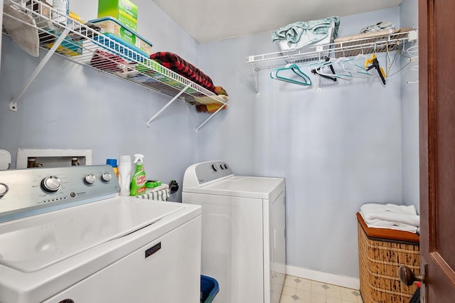 clothes washing area featuring laundry area, baseboards, light floors, and independent washer and dryer