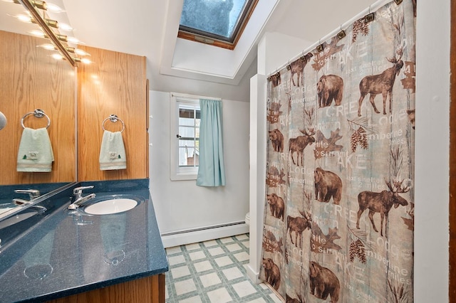 bathroom featuring a skylight, toilet, a baseboard radiator, tile patterned floors, and vanity