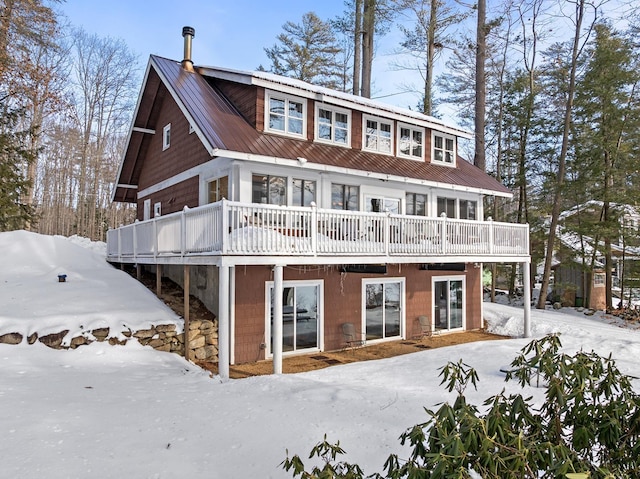 view of front of home featuring metal roof and a wooden deck