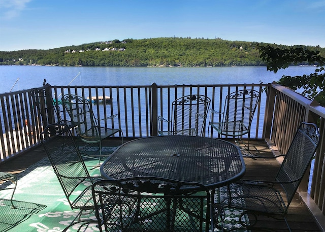 wooden terrace with a water view and a forest view