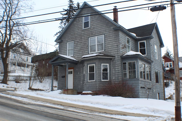 view of front facade with a chimney and fence