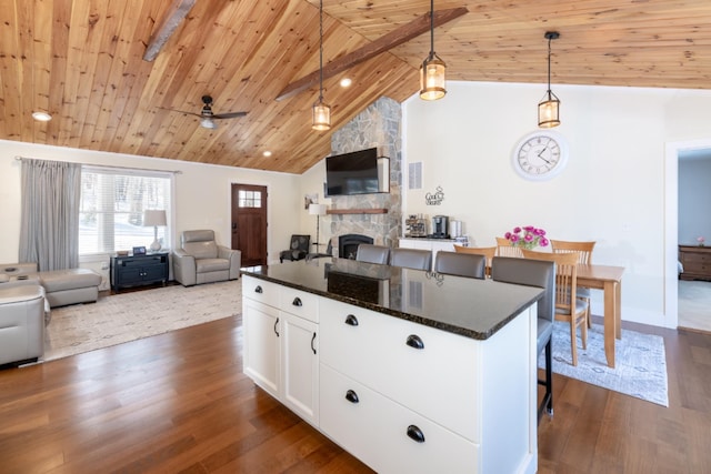 kitchen with wood ceiling, open floor plan, dark wood-style flooring, and a stone fireplace