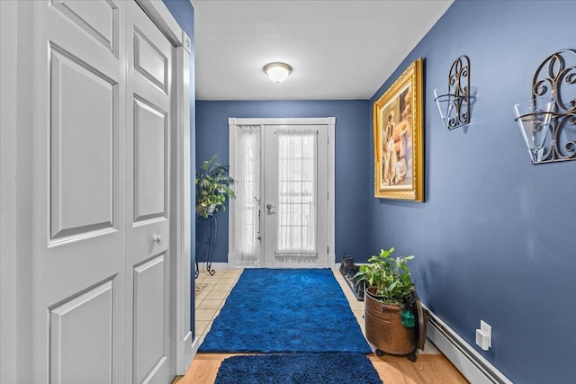 doorway with a baseboard heating unit and baseboards