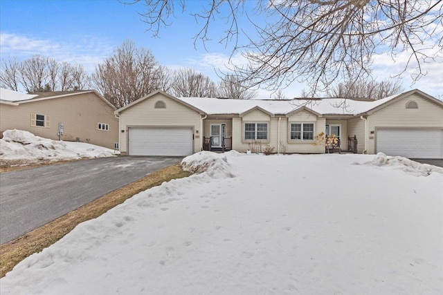 single story home with an attached garage and aphalt driveway