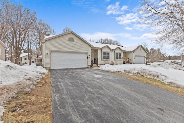 ranch-style house featuring a garage and aphalt driveway