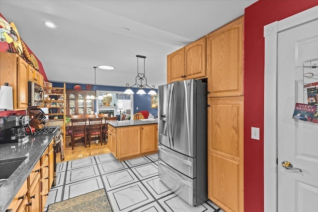 kitchen featuring decorative light fixtures, stainless steel appliances, recessed lighting, dark stone countertops, and a chandelier