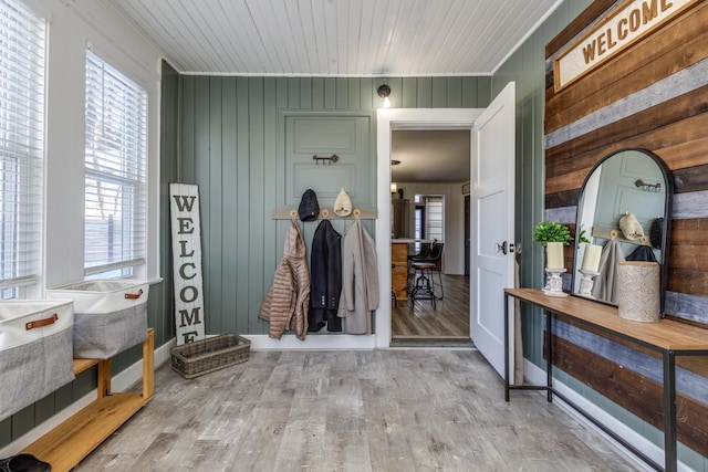 mudroom featuring ornamental molding, wooden ceiling, wooden walls, and wood finished floors