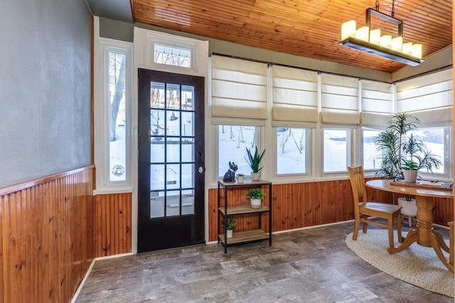 interior space featuring wooden ceiling, wainscoting, wood finished floors, and wood walls