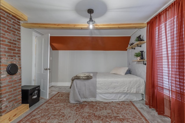 bedroom with a wood stove, lofted ceiling with beams, and baseboards