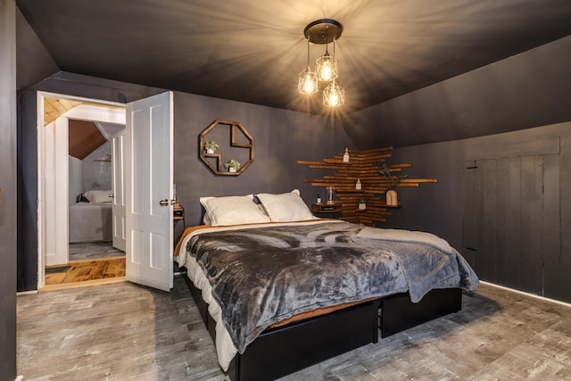 bedroom with lofted ceiling and wood finished floors