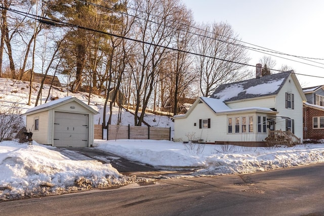 exterior space with an outbuilding, a chimney, a detached garage, and fence