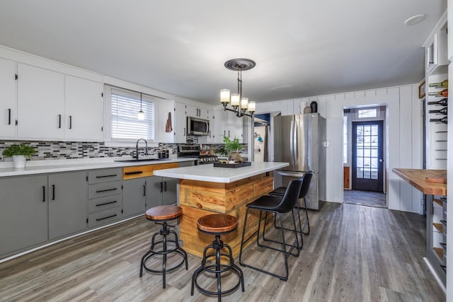 kitchen with a healthy amount of sunlight, appliances with stainless steel finishes, gray cabinets, and light countertops