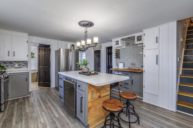 kitchen with light countertops, light wood-type flooring, plenty of natural light, and a notable chandelier