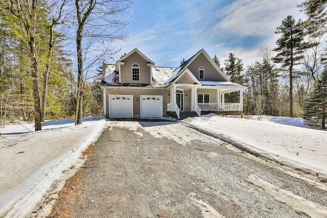 view of front of home featuring covered porch, an attached garage, and dirt driveway