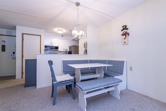 dining room with a textured ceiling and light colored carpet