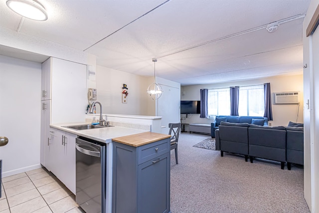 kitchen featuring wood counters, open floor plan, a peninsula, an AC wall unit, and a sink