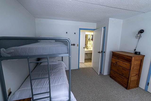 carpeted bedroom featuring a textured ceiling and a sink