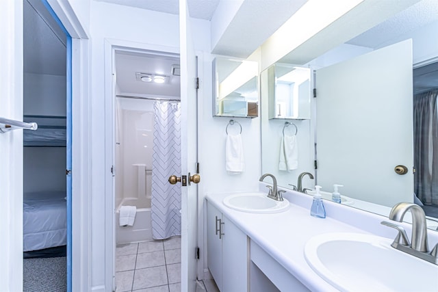 full bathroom featuring double vanity, a sink, and tile patterned floors