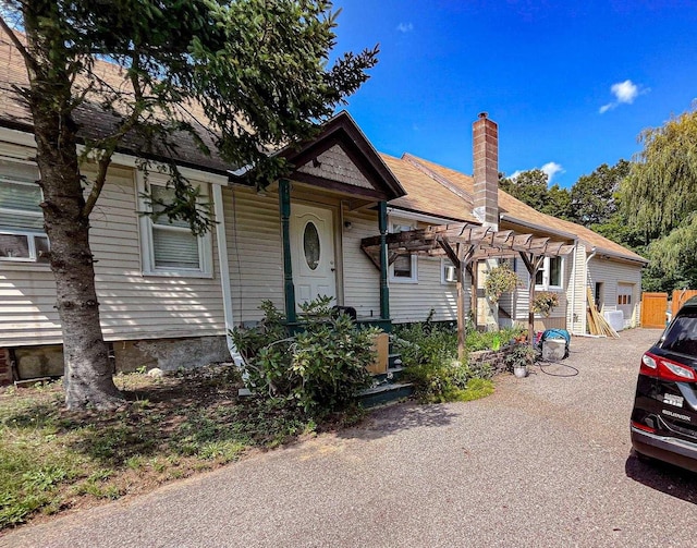 view of front of home featuring a chimney and a pergola