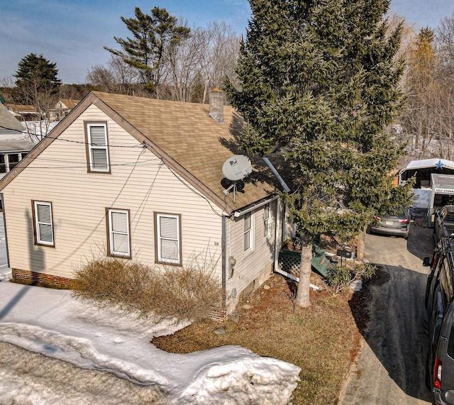 view of property exterior with a shingled roof