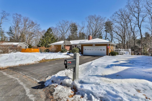 single story home featuring a garage, aphalt driveway, and a chimney