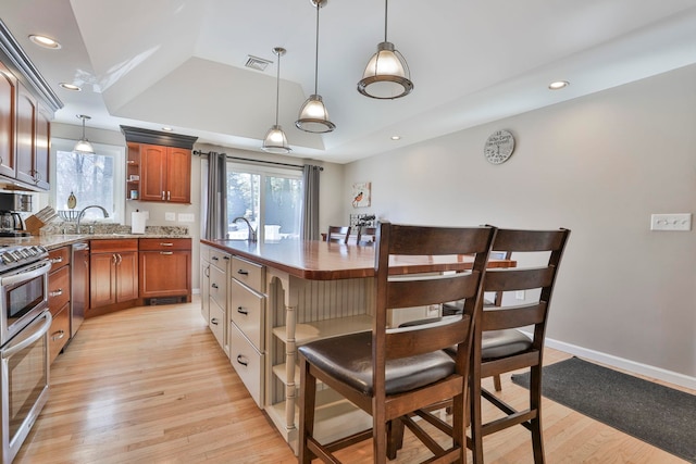 kitchen featuring stainless steel appliances, light wood-type flooring, a healthy amount of sunlight, and open shelves