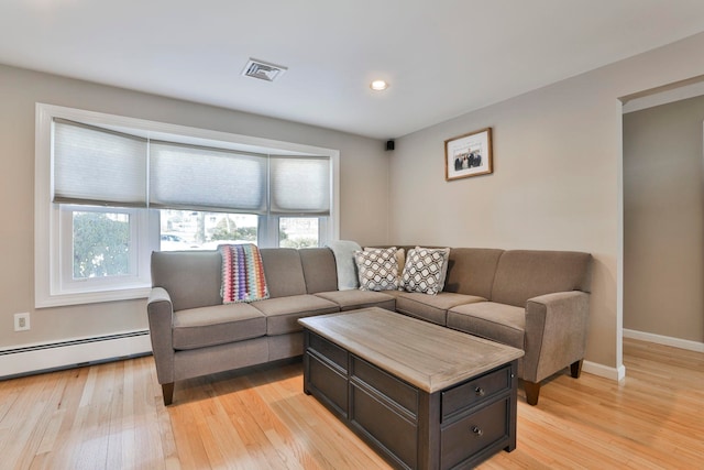 living area with light wood-style floors, baseboards, visible vents, and baseboard heating