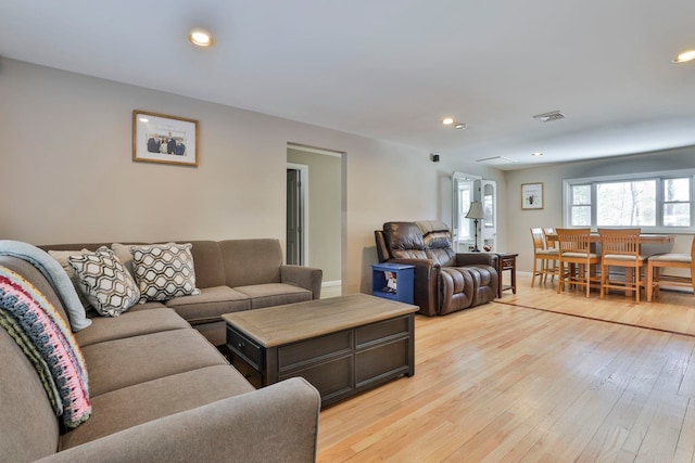 living room featuring baseboards, light wood finished floors, visible vents, and recessed lighting