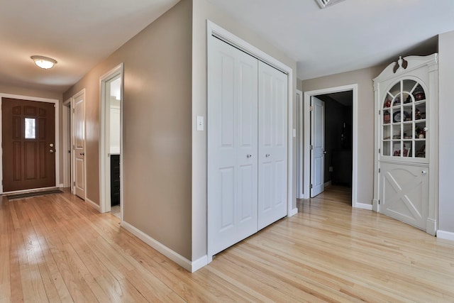 foyer entrance with light wood finished floors and baseboards