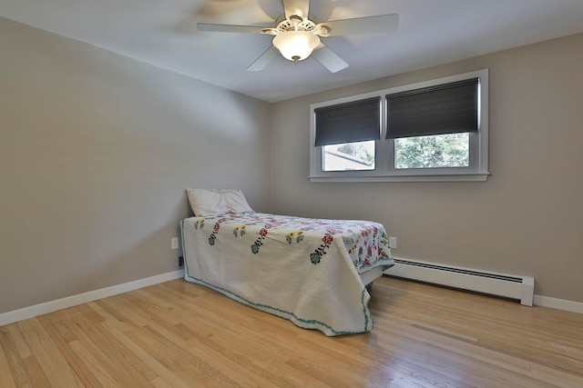 bedroom with baseboards, ceiling fan, baseboard heating, and wood finished floors