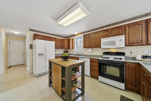 kitchen with light floors, open shelves, butcher block counters, a sink, and white appliances