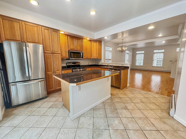 kitchen featuring crown molding, stainless steel appliances, brown cabinetry, light tile patterned flooring, and a peninsula