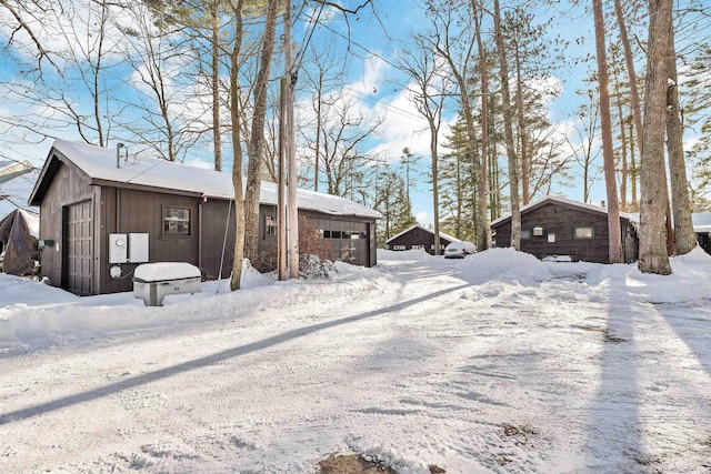 snow covered property with a garage