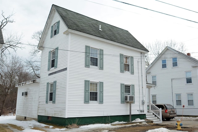 back of property featuring entry steps and roof with shingles