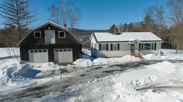 colonial inspired home featuring a garage, board and batten siding, and an outbuilding