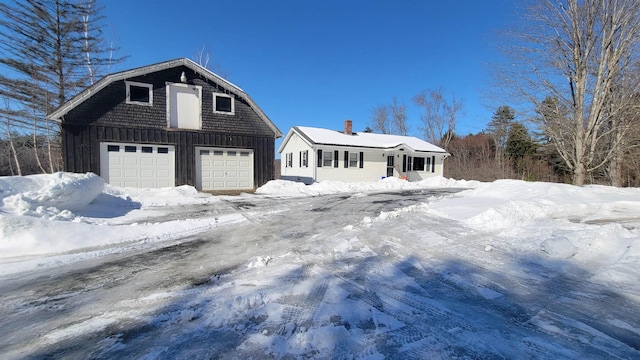 colonial inspired home with a detached garage, board and batten siding, and an outdoor structure