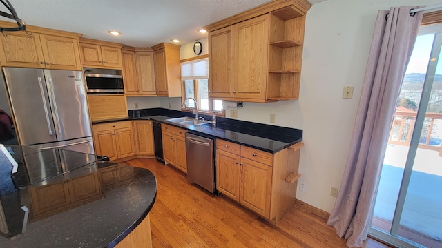 kitchen with open shelves, stainless steel appliances, recessed lighting, light wood-style flooring, and a sink